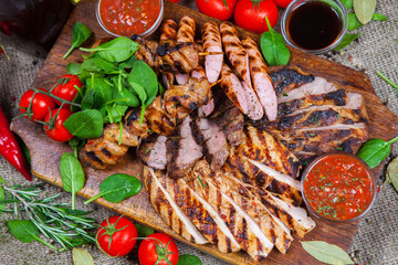 Mixed grilled meat platter. Assorted delicious grilled meat with vegetable. Mixed grilled meat with pepper sauce and vegetables.