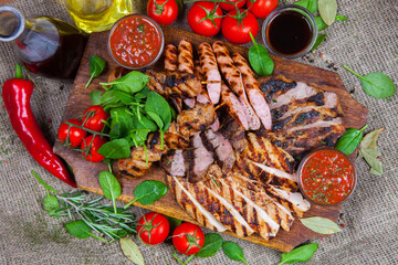 Mixed grilled meat platter. Assorted delicious grilled meat with vegetable. Mixed grilled meat with pepper sauce and vegetables.