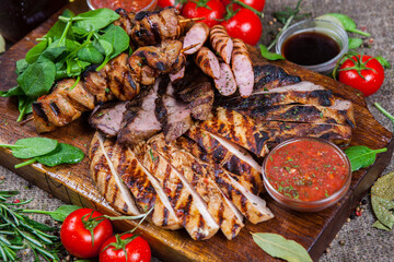 Mixed grilled meat platter. Assorted delicious grilled meat with vegetable. Mixed grilled meat with pepper sauce and vegetables.