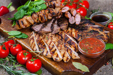 Mixed grilled meat platter. Assorted delicious grilled meat with vegetable. Mixed grilled meat with pepper sauce and vegetables.