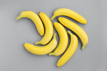 Group of yellow bananas on gray background. Top view, pattern in trendy colors.