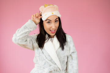 Portrait of a pretty young woman smiling in sleeping clothes and sleeping mask.
