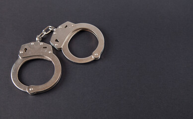 Metal handcuffs on an isolated black background.