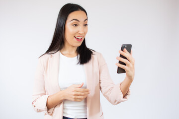 Fototapeta premium Portrait of a happy young business woman using mobile phone isolated over white background
