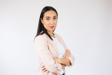 Portrait of a cheerful business woman standing with arms folded isolated over white background