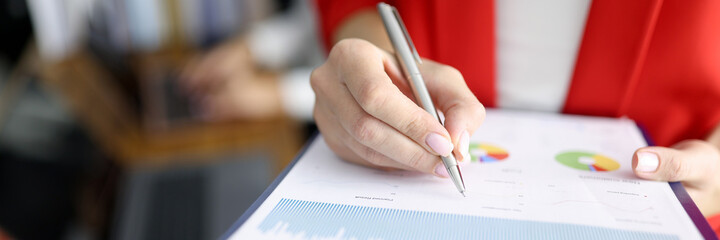 Business woman in red jacket holds clipboard with documents and pen closeup. Maintaining personnel documentation concept.