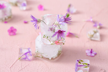 Fototapeta na wymiar Beautiful flowers frozen in ice on color background