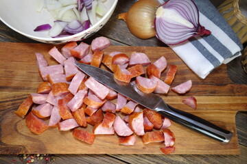 Sausage cut on a wooden board and onion . Preparation of the dish - letcho
