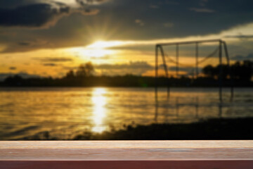 Obraz premium Blurred golden autumn background at lake with wooden table empty for concept. 