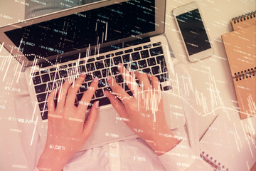 Double exposure of woman hands working on computer and forex chart hologram drawing. Top View. Financial analysis concept.