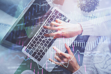 Double exposure of woman hands working on computer and forex chart hologram drawing. Top View. Financial analysis concept.