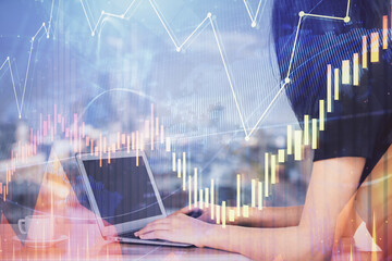 Double exposure of businesswoman hands typing on computer and forex chart hologram drawing. Financial analysis concept.