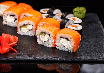 Two different types of sushi rolls on a stone board. Japanese cuisine.