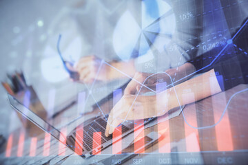Multi exposure of woman hands typing on computer and financial chart hologram drawing. Stock market...