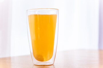 Tablet of calcium effervescent melting in a drinking water close up with copyspace. 