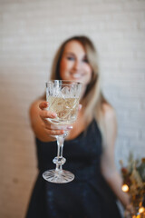 Fashion young beautiful woman in luxury dress and makeup with glass of champagne. christmas and new year. sparkles confetti.