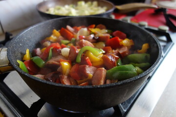 Hot Traditional Hungarian dish na frying pan - letcho with sausage, zucchini and paprika