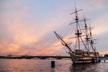 Old sailing frigate at the pier at sunset