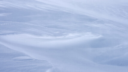 A mountain slope covered with a layer of snow.