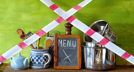 gastronomy corona lockdown, restaurant kitchen utensils with warning tape,symbolic picture