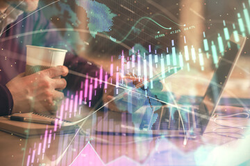 Double exposure of man's hands holding and using a phone and financial graph drawing. Analysis concept.