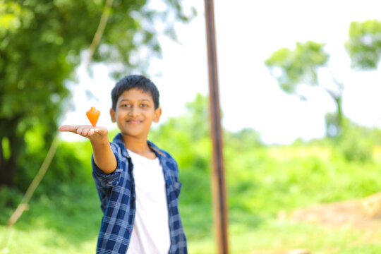 Cute indian little child playing Lattu, Bhovra or Bambaram is a traditional throwing top using thread, played mainly in India