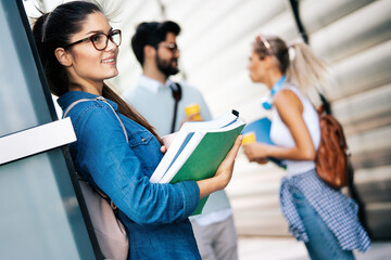Happy group of friends studying and talking together at university