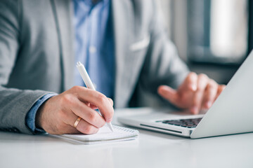 Fototapeta premium Businessman planning work, writing notes in the office.