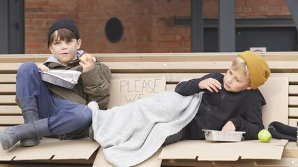 Poor street kids enjoy meal on street, eating donationa food. Social issues, poverty problem concept.