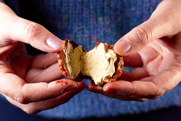 Little marshmallow cookies cut in half in the hands of a woman