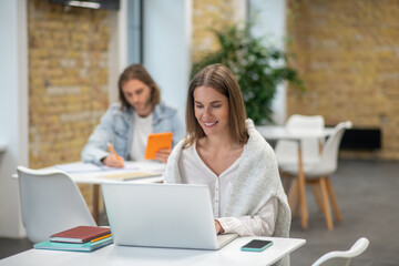 Young man and woman sitting at the tables and studying