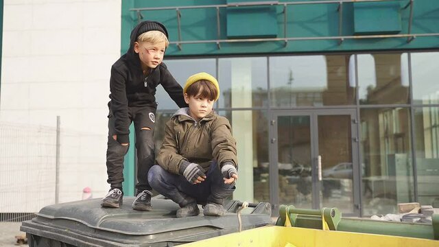 Street boys looking at something, spending life outdoors, outcast boy pointing finger at side, show something.