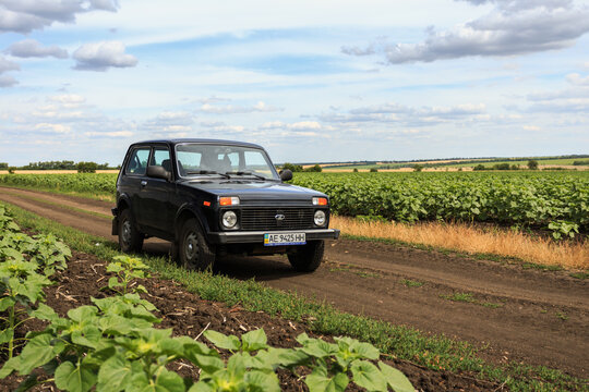Dnipropetrovsk region, Ukraine - july 08, 2017: VAZ Niva blue-green color on the dirt road near the sunflower field