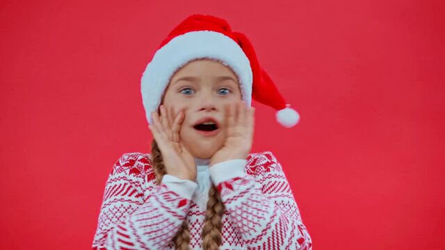 shocked girl in santa hat isolated on red