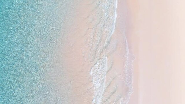 Aerial view Top view of the sunsets over sea. Beautiful sea waves. Pink sand and amazing sea. Atlantic Ocean beach sunsets. Water texture. Top view of the fantastic natural. 4K Summer sunset seascape.