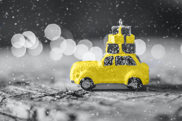Christmas Holiday Card. Yellow toy car and gray bokeh. Color of the Year 2021