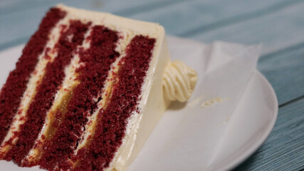 red velvet cake on white plate isolated blue wooden background 