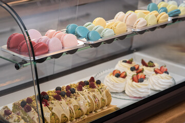 Macarons of different colors on a showcase in a cozy coffee shop