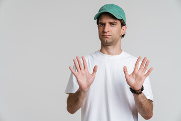 Handsome displeased guy showing stop gesture on camera