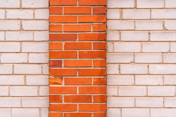Wall of white brick with a strip of red bricks