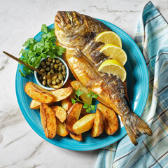 grilled fish with potato on a plate