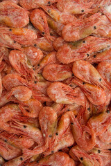 Close-up of a stack of frozen pink shrimp. Frozen shrimp background. veritable format, texture.