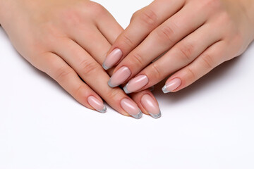 Fototapeta premium French silver manicure on long nails on a white background close-up. Bolero nail shape.