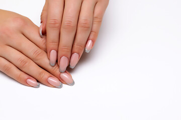 French silver manicure on long nails on a white background close-up. Bolero nail shape.