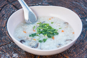 Boiled rice with pork in white bowl on table in morning.