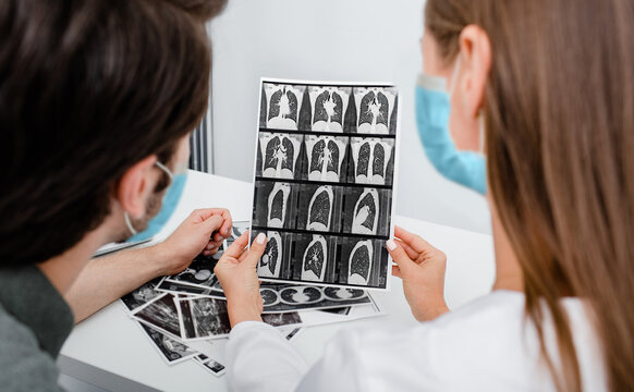 Pulmonologist Wearing In Protective Mask Showing Man Patient A CT Scan Of His Lungs. Pneumonia, Coronavirus, Lung Disease