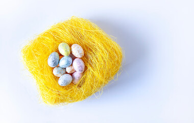 Colorful plastic Easter eggs in nest. Festive table decoration for traditional celebration.