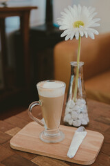 artificial white gerbera flower with hot latte cappuccino mocha coffee.