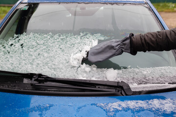 Hand cleaning windscreen from snow