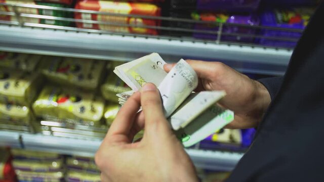 Man counts Libyan dinar bills, Close-up of men's hands counting money in cash at a store